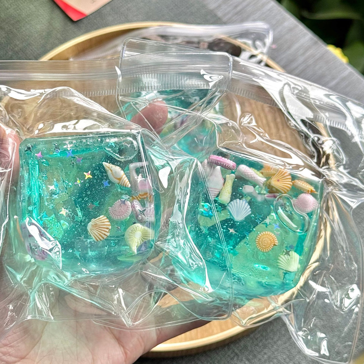 Två squishy-kuber med snäckor och glitter i förpackning